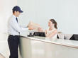 Delivery man handing box to receptionist