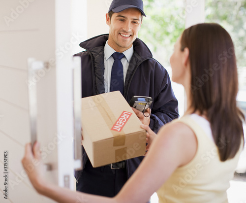 Photo: Delivery man handing box to woman Delivery man handing box to woman