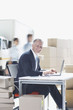Supervisor working on laptop in shipping area