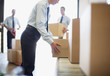 Foto: Workers taking boxes from conveyor belt in shipping area Workers taking boxes from conveyor belt in shipping area
