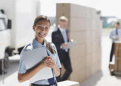 Photo: Worker standing with clipboard in shipping area Worker standing with clipboard in shipping area