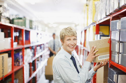 Photo: Worker putting box on shelf Worker putting box on shelf