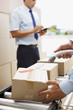 Worker scanning box on conveyor belt in shipping area
