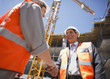 Construction workers shaking hands on construction site