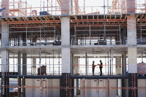 Photo: Construction workers shaking hands on construction site Construction workers shaking hands on construction site