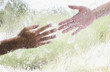 Two hands reaching out behind glass