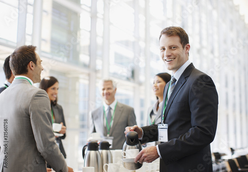 Photo: Business people drinking coffee in office Business people drinking coffee in office