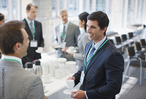 Photo: Business people drinking coffee in office Business people drinking coffee in office