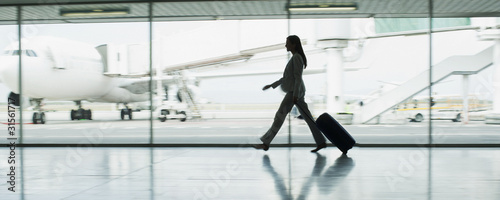 Photo: Businesswoman with suitcase in airport Businesswoman with suitcase in airport