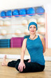 Young woman doing yoga on the floor of gym