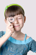 The girl looks through a magnifier