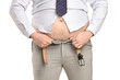 Overweight man trying to fasten too small clothes