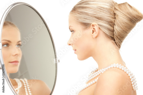 Photo: beautiful woman with pearl beads and mirror beautiful woman with pearl beads and mirror