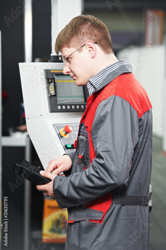 Photo: worker at machining tool workshop worker at machining tool workshop