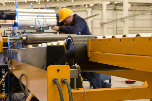 Photo: Worker using steel coil processing machine focus on machine. Worker using steel coil processing machine focus on machine.