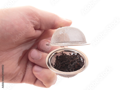 Photo: Tea strainer in the hand. Isolated on white Tea strainer in the hand. Isolated on white