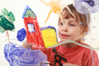 little girl in red t-shirt paints on glass, house, tree