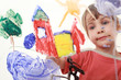 beautiful little girl paints on glass, house, tree