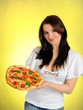 Foto: Pretty young casual girl with tasty pizza in delivery paper box. Pretty young casual girl with tasty pizza in delivery paper box.
