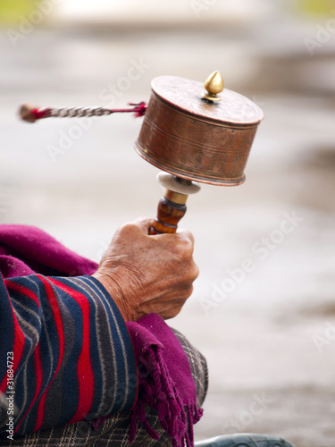 Photo: An older women spinning her prayer wheel An older women spinning her prayer wheel