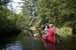 Muskokas, Ontario, Canada; Couple Canoeing Down A River