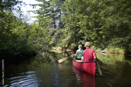 Photo: Muskokas, Ontario, Canada; Couple Canoeing Down A River Muskokas, Ontario, Canada; Couple Canoeing Down A River