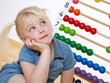Foto: Little blond child using an abacus to learn Little blond child using an abacus to learn