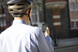 A businessman on his bicycle, looking at his mobile phone