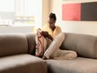 African American woman reading a book on the couch