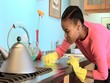 African American woman cleaning countertop in kitchen