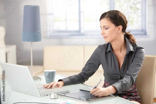 Photo: Young graphic designer working at home Young graphic designer working at home