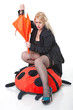 young blonde woman with umbrella straddles big plaything