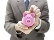 Businessman putting coin into the piggy bank Businessman putting coin into the piggy bank