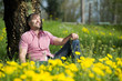 Mann macht Pause an einem Baum.