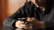 Young man typing on mobile phone. Shot with slider.