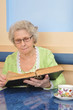 old woman holding a book for reading