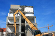 gelber Abrissbagger & Abrisshaus, frontal