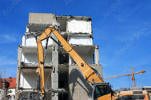 Photo: gelber Abrissbagger & Abrisshaus, frontal gelber Abrissbagger & Abrisshaus, frontal