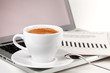 Cappuccino cup with laptop and newspaper Cappuccino cup with laptop and newspaper
