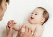 The happy baby playing with hands of mum