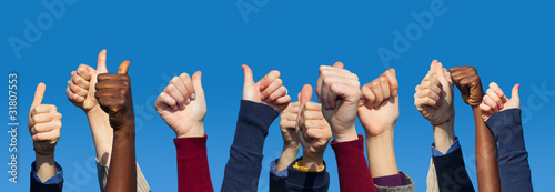 Photo: Multiracial Thumbs Up Against Blue Sky Multiracial Thumbs Up Against Blue Sky