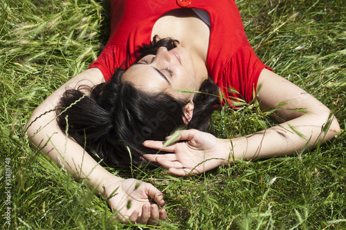 Photo: jeune femme au repos couchée dans l'herbe jeune femme au repos couchée dans l'herbe