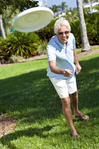 Photo: Happy Senior Man Throwing Frisbee Outside in Sunshine Happy Senior Man Throwing Frisbee Outside in Sunshine
