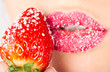 woman's mouth with red strawberry covered with sugar woman's mouth with red strawberry covered with sugar