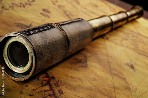 Photo: Close-up of a spyglass on the old map Close-up of a spyglass on the old map