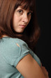 Young woman against black background.