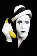 mime in white hat holding a banana in his hand