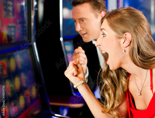 Photo: Couple in Casino on slot machine Couple in Casino on slot machine