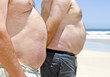Close up of two obese fat men of the beach