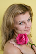 Foto: Beautiful young girl with pink rose on yellow background Beautiful young girl with pink rose on yellow background